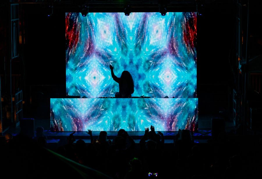 DJ stage with blue kaleidoscopic visuals at Re/Evolution