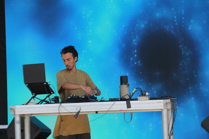 DJ performing in front of blue cosmic visuals