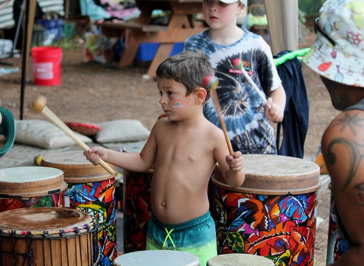 A child playing brightly painted hand drums