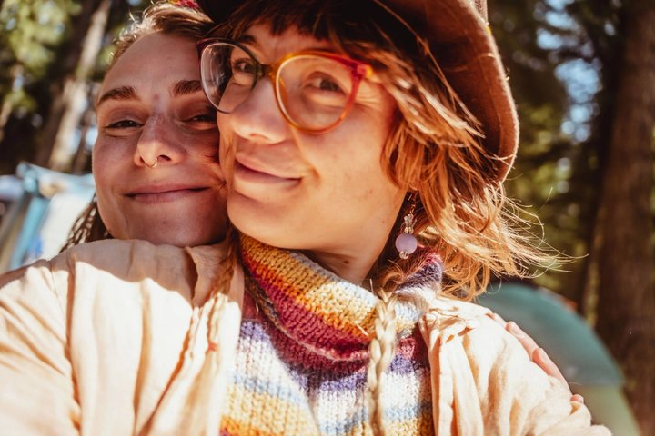Two festival attendees smiling together in afternoon sunlight
